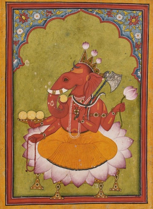A traditional painting of the Hindu deity Ganesha, depicted with a red elephant head, seated on a pink lotus throne and adorned with jewelry while holding an axe, a lotus flower, and a bowl of sweets.