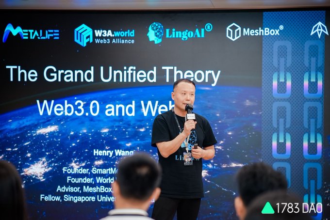 A man in a black LingoAI t-shirt speaking into a microphone during a talk titled "The Grand Unified Theory of Web3.0 and Web..." with logos for METALIFE, W3A.world, LingoAI, MeshBox, and a "1783 DAO" watermark.