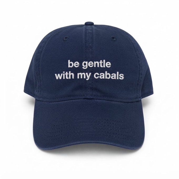A navy blue baseball cap with white embroidered text reading 'be gentle with my cabals'.