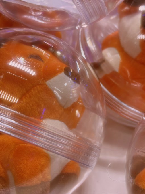 Multiple containers of plush mushrooms with orange spotted caps and white stems, packaged in clear plastic cups.