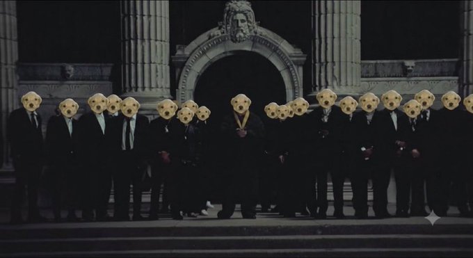 A cinematic still showing a group of people in dark suits standing in front of an ornate stone building with columns, all wearing identical yellow/pale masks with holes for eyes and mouths.