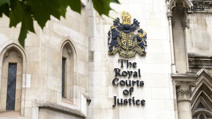 A London court's exterior prominently displays "The Royal Courts of Justice" beneath an ornate royal coat of arms, illustrating the venue where a judge ruled that Chinese fraud victims cannot use English law to claim £3.8 billion worth of seized Bitcoin.