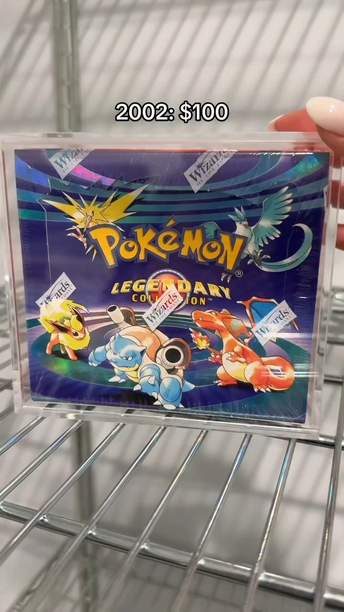 A sealed box of Pokemon Legendary Collection cards sits on a wire rack with text reading '2002: $100'.