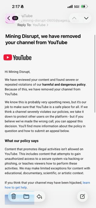 A screenshot of an email from YouTube addressed to 'Mining Disrupt' stating the channel has been removed due to violations of harmful and dangerous policy regarding content that promotes illegal activities like hacking or phishing.