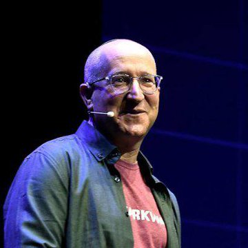 A bald man wearing a white beshtel on his chest, with a microphone visible on the side of his face, speaks at what appears to be a conference or event. The accompanying post suggests he is StarkWare CEO Eli Ben-Sasson, though I cannot verify the identity from the image alone, and references the ticker $LIT.