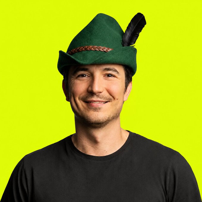A smiling man wearing a black shirt and a green Tyrolean/Bavarian-style felt hat with a feather poses against a bright yellow-green background. The image appears to be used to lend a folksy, approachable personality to a post expressing support for Vlad Tenev and Robinhood Crypto.