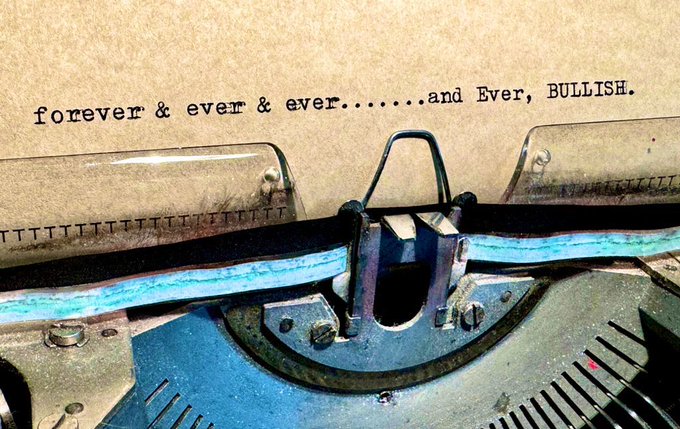 A close-up of a vintage typewriter with typed text on paper reading 'forever & ever & ever.......and Ever, BULLISH.'