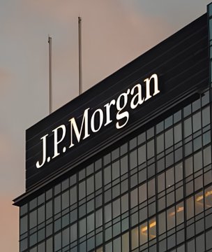 An exterior view of a dark glass skyscraper featuring the 'J.P.Morgan' company logo prominently displayed near the top against a cloudy sky.