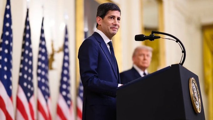 A man in a dark suit stands at a podium bearing the Presidential Seal, with American flags and another man visible in the background. While the post discusses CPI data and market predictions, the image itself shows a formal political setting with no visible text, numbers, or tickers—making the connection to the economic commentary limited beyond sharing a news-style visual backdrop.