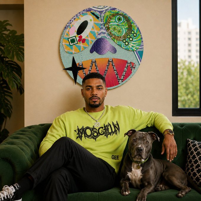 A man in a bright neon green 'MOSCOT' sweatshirt sits on a green velvet couch beside a brown and white pit bull-type dog, with a colorful abstract circular artwork hanging on the wall behind them.