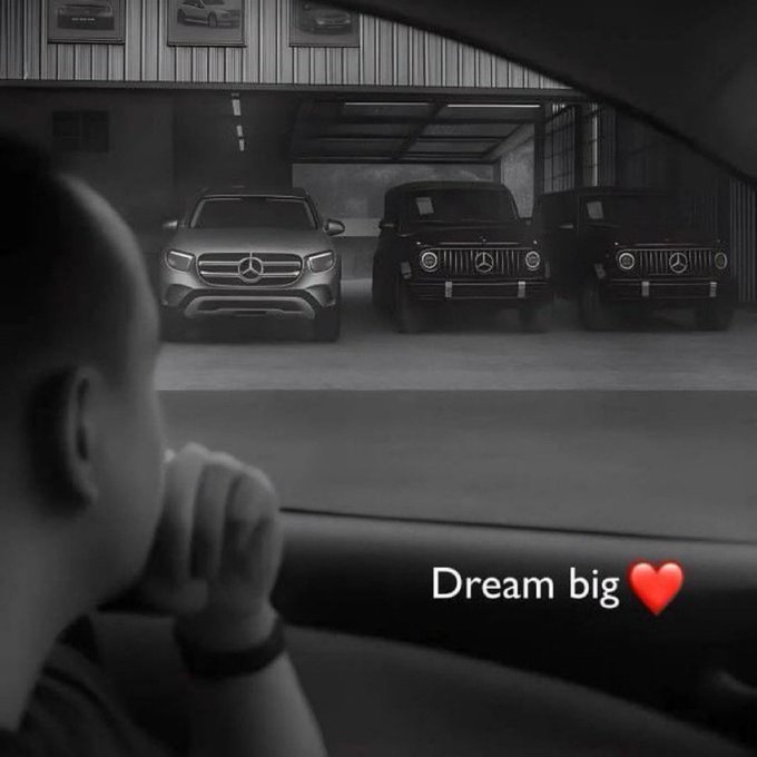 A black-and-white photo of a child looking through a car window at three parked Mercedes-Benz G-Class SUVs in a garage, captioned 'Dream big' with a red heart emoji.