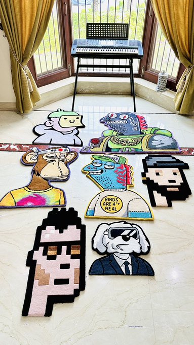 Several pixel-art and cartoon character rugs are displayed on a tiled floor in front of a music keyboard, including characters labeled 'BIRDS AREN'T REAL'.