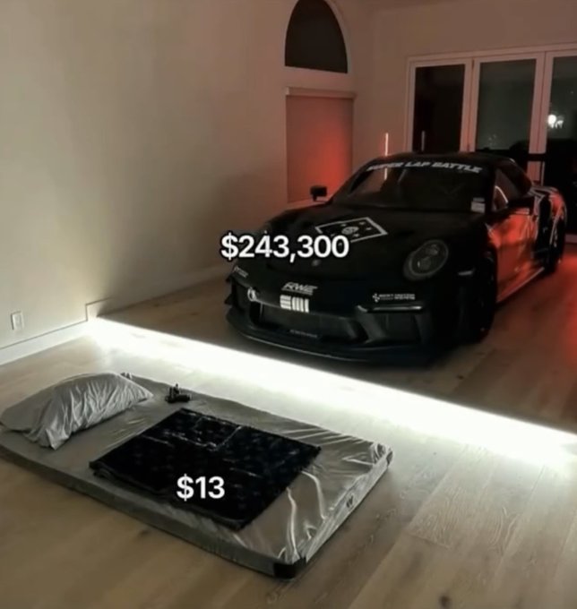 A sleek black Porsche (with "LAP BATTLE" decal) is parked in a spacious room at $243,300, while a simple air mattress on the floor is priced at just $13—ironically contrasting the crypto bro's prioritization of flashy luxury over basic comfort.
