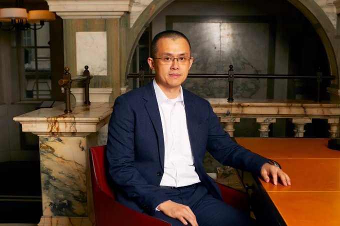 A bespectacled man in a dark suit and white shirt sits at a polished wooden table in an elegant, arch-framed interior, likely representing CZ (Changpeng Zhao) of YZi Labs. The image pairs with the post's context to illustrate the crypto executive discussing his fund's well-timed investments during the crypto winter.
