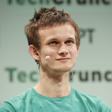 A close-up portrait of Vitalik Buterin, the co-founder of Ethereum, wearing a green t-shirt and a small headset microphone at a TechCrunch event.