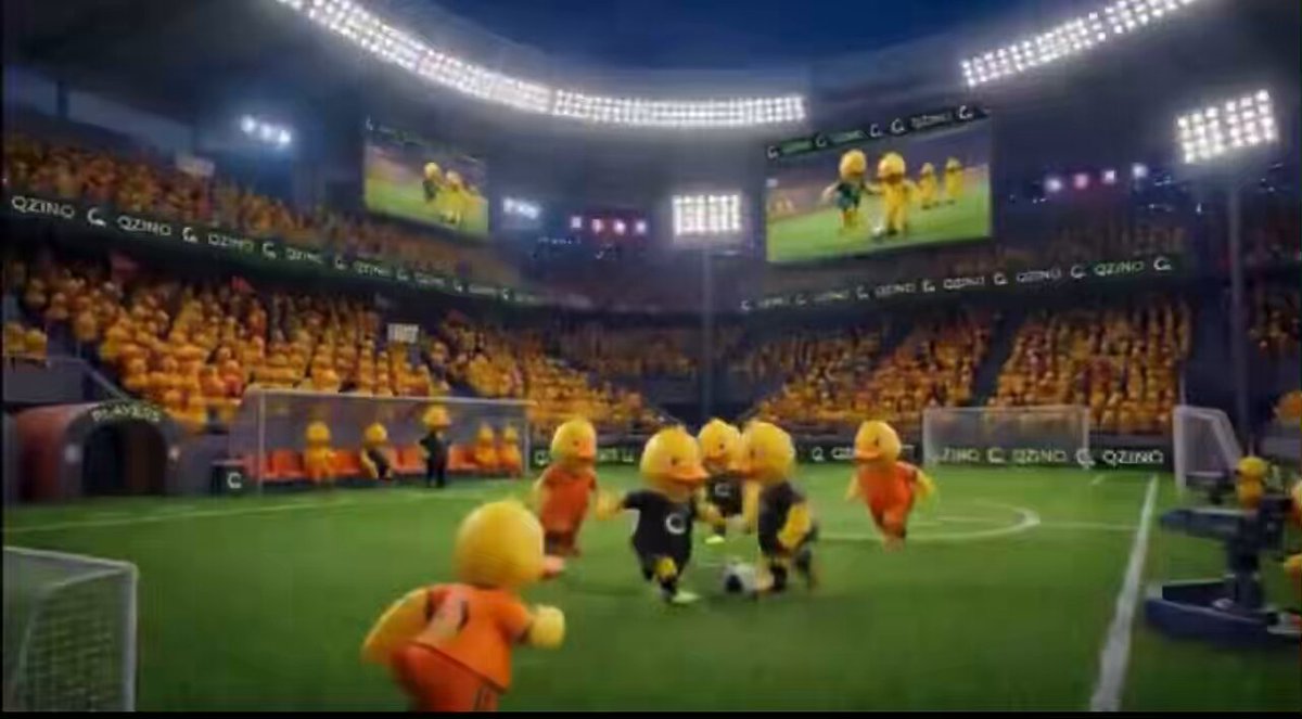 The image features a group of cartoon characters playing soccer on a field with a large screen behind them displaying a soccer game, likely from the movie "GQQuack Sports Betting." The characters are dressed in yellow outfits and appear to be enjoying themselves as they play. The scene is set against a stadium backdrop, emphasizing the popularity and excitement surrounding the movie's release.