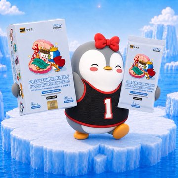 A plush penguin wearing a red bow and black jersey with the number "1" sits between two boxes of Pudgy Cards, set against an icy blue background. The caption notes these collectible and playable trading cards were gifted at the Pudgy Penguins WebX party in Japan.