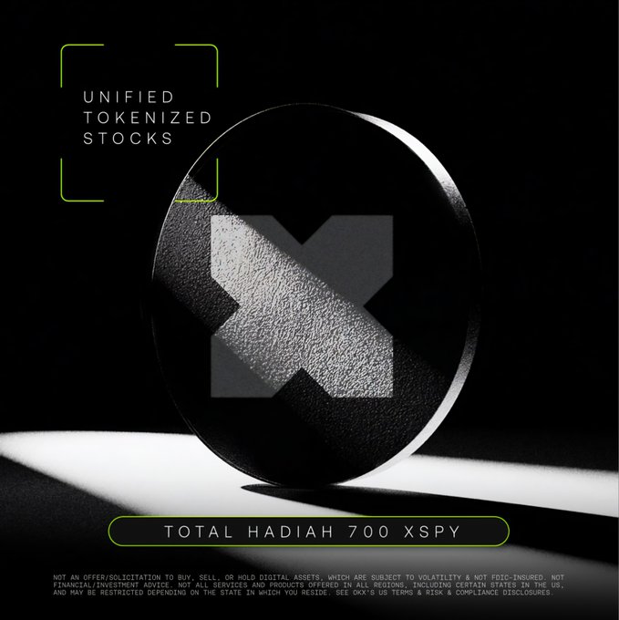 A sleek promotional graphic for OKX's Unified Tokenized Stocks (UTS) feature displays a textured metallic coin bearing the OKX "X" logo against a black background, with a banner announcing "TOTAL HADIAH 700 XSPY" prize giveaway and a regulatory disclaimer noting the digital assets are not FDIC-insured and subject to volatility.