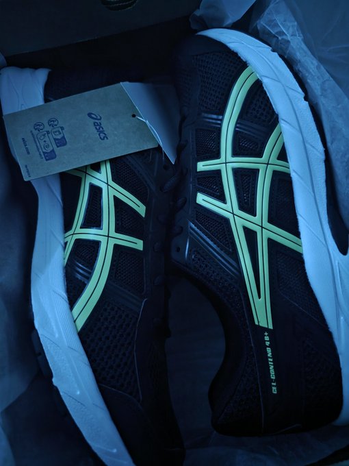 A pair of black Asics sneakers with glowing mint-green cross stripes rest in a box with an attached Asics tag, the shoes' grid-like design symbolizing the interconnected, decentralized nature of Web3 highlighted in the caption "Web3 did it!"