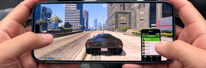 A person holds a smartphone horizontally displaying gameplay of Grand Theft Auto V, with a black sports car driving through a city street and the in-game phone contacts menu open on screen.