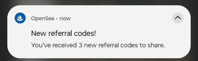 A smartphone notification from OpenSea stating 'New referral codes! You've received 3 new referral codes to share.'