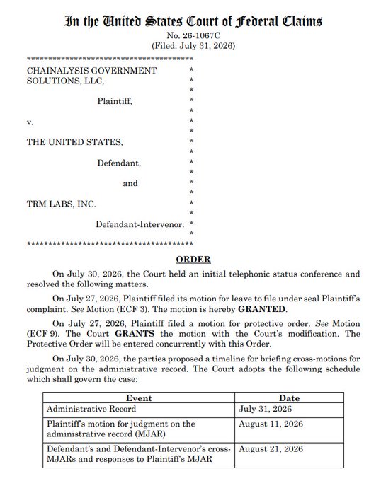 The image shows a court order from the United States Court of Federal Claims (Case No. 26-1067C, filed July 31, 2026) in the lawsuit *Chainalysis Government Solutions, LLC v. The United States and TRM Labs, Inc.*, granting Chainalysis's motions to file under seal and for a protective order while establishing a briefing schedule on cross-motions for judgment on the administrative record—directly supporting the accompanying post's description of Chainalysis's suit challenging DHS/ICE's award of a contract to TRM Labs.