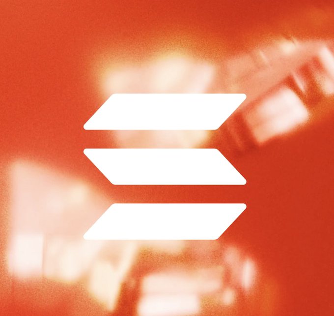 Three white arrow-shaped bars form a stacked logo against a blurred red background featuring what appears to be the same emblem in faded tones. The clean, minimalist design paired with the "What is coming next...?" caption suggests a teaser or announcement for a brand reveal.