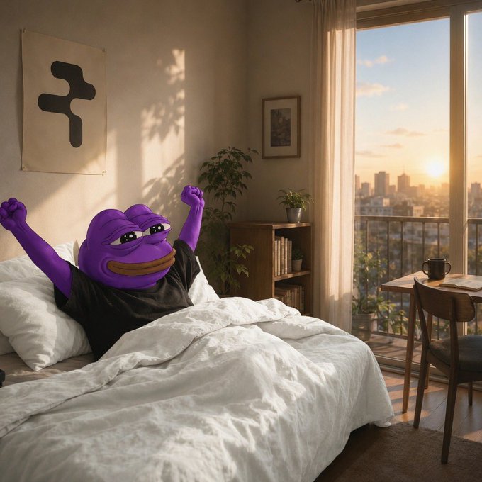 A purple Pepe-like character stretches cheerfully in bed at sunrise, with an urban skyline visible through the window. The image evokes a "Good Morning" vibe that pairs with the GM greeting, while the cozy bedroom setting mirrors the relaxed, optimistic tone of Rialo's vision for tokenized real-world assets becoming practical, everyday tools within applications.