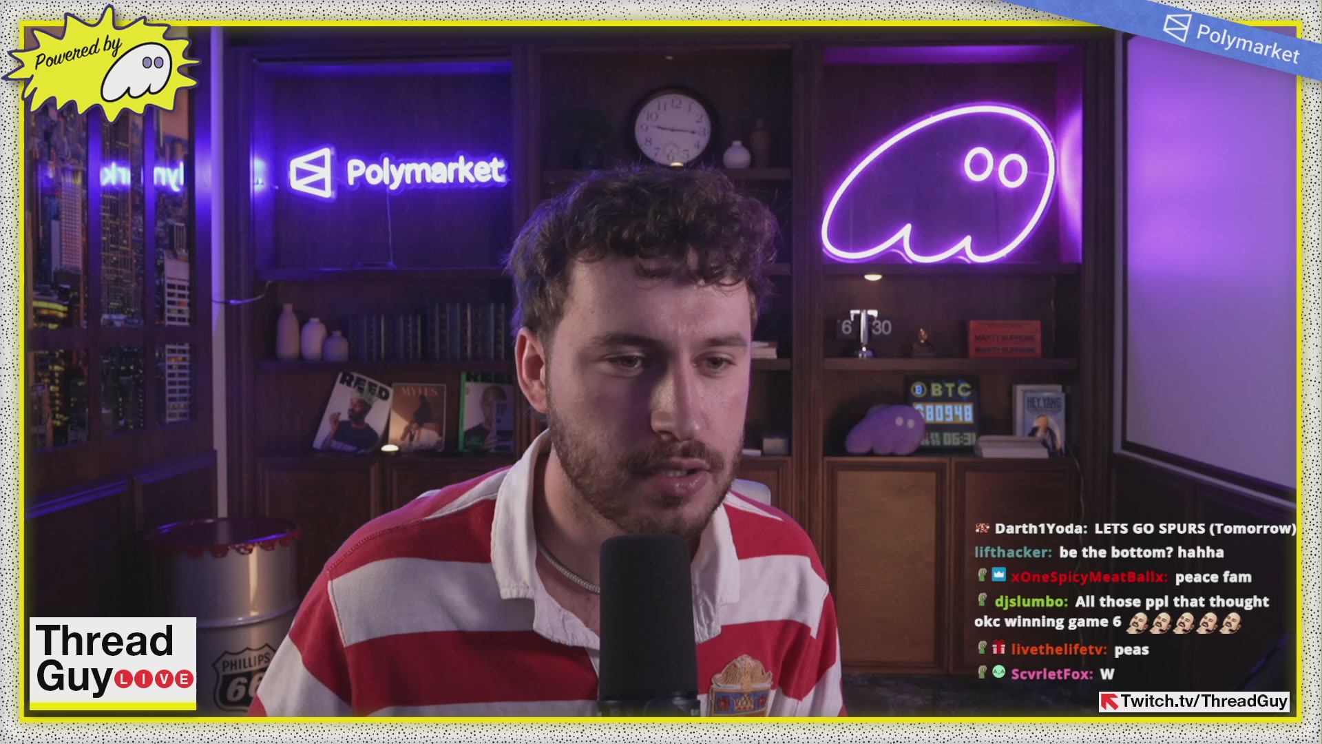The image shows a man wearing a red and white striped shirt sitting at a microphone, likely participating in an online radio show or podcast. The background features a clock and a neon sign that reads "POLYMARKET". There are also books visible on a shelf nearby.