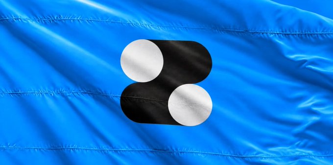 A blue satin flag with a black and white interlocking loop logo, identified as the corporate branding for the blockchain company Polygon (MATIC).