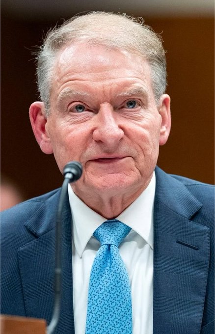 The image shows a close-up of an older man with blue eyes and gray hair, wearing a blue checkered suit jacket, white shirt, and light blue patterned tie, speaking into a microphone during what appears to be a formal hearing or testimony.

The post refers to "Chair Atkins" of the SEC, suggesting the man pictured is SEC Chair Paul Atkins, who the post is encouraging to ramp up crypto asset regulations ahead of an August 14 SEC deliberation, bypassing the need to wait for the CLARITY Act.