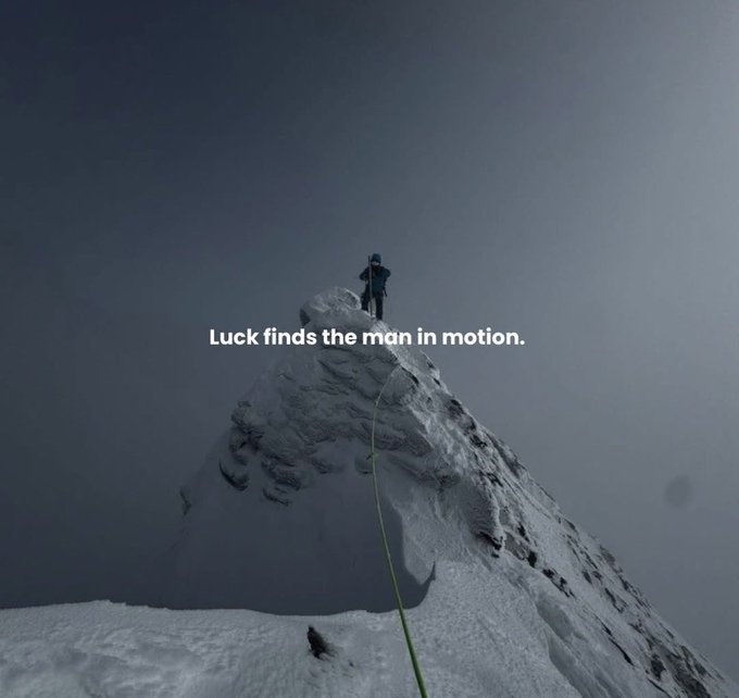 A lone climber stands atop a snow-covered mountain peak with a rope trailing behind, accompanied by the overlaid text "Luck finds the man in motion."

The image visually reinforces the post's message about staying active and adaptable in the crypto space—portraying the solitary climber conquering a harsh, unforgiving summit as a metaphor for navigating brutal bear markets through continuous movement, positioning, and seizing opportunities as they arise.