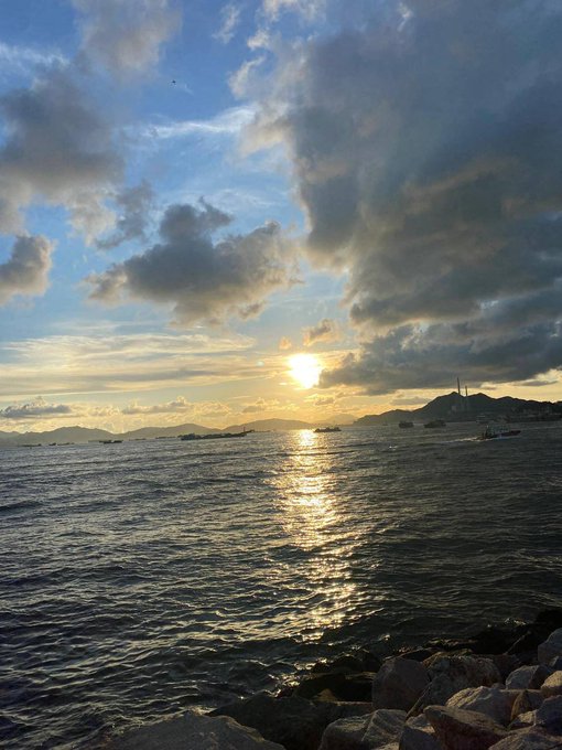 The image shows a beautiful sunset over water, with the sun setting behind some clouds. There are several boats visible in the background, suggesting that this scene takes place near a harbor or a body of water where people can enjoy boating activities. The photo is captioned "Can I Get GM @quipnetwork", which implies that it was taken by someone who wants to share their experience with others on social media platforms like Instagram or Facebook.

The image also features a bird flying in the sky, adding to the overall atmosphere and beauty of the scene.
