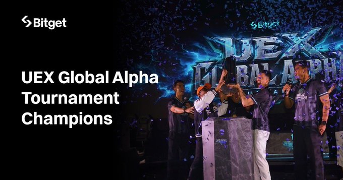 A group of players in matching jerseys hoist a championship trophy on stage during the Bitget UEX Global Alpha Tournament, with "UEX Global Alpha" displayed prominently in the background and confetti falling around them.
