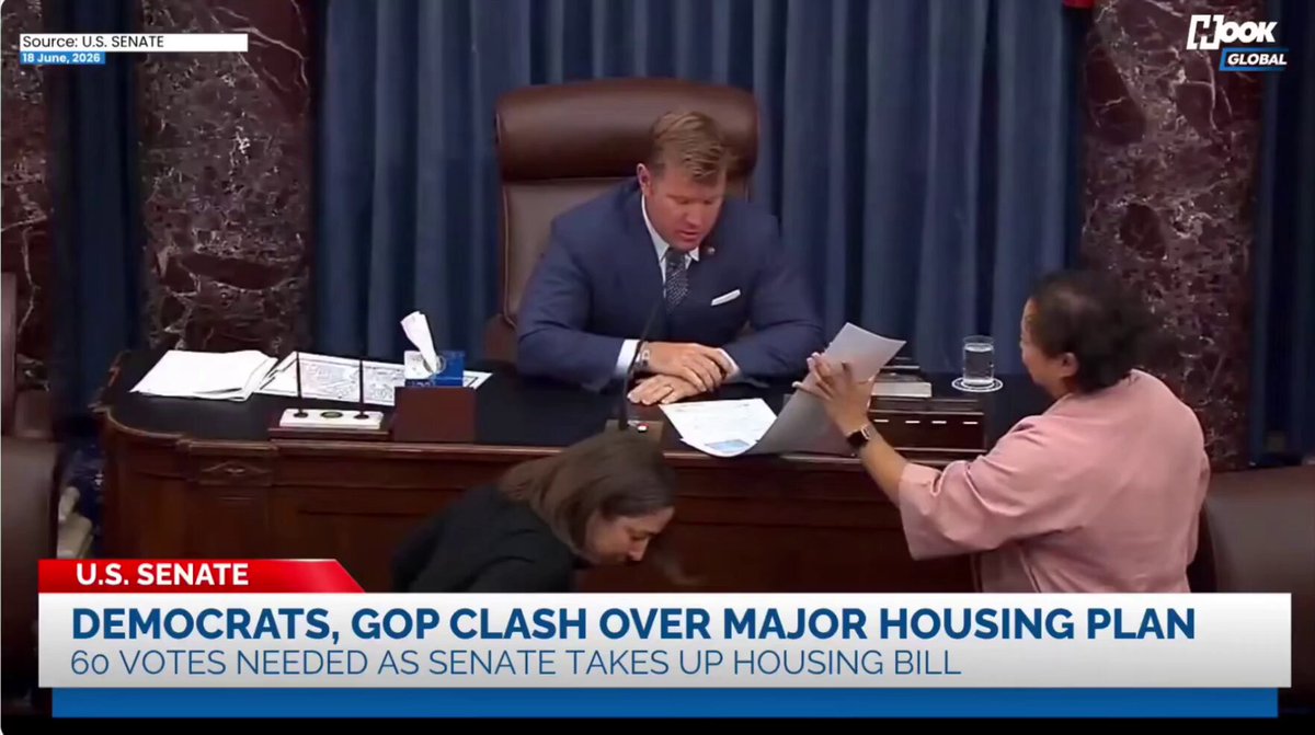 The image shows a news report about a bill passed by the U.S. Senate, which bans the creation of a central bank digital currency (CBDC). The text in the image reads "BREAKING: UNITED STATES SENATE JUST OFFICIALLY PASSED THE FINAL BILL TO BAN THE FED FROM CREATING A CENTRAL BANK DIGITAL CURRENCY UNTIL 203 0 THE BILL NOW HEADS TO THE HOUSE THIS IS A MASSIVE WIN FOR BTC AND FREEDOM". The image also shows a man sitting at his desk, and two women are standing behind him.
