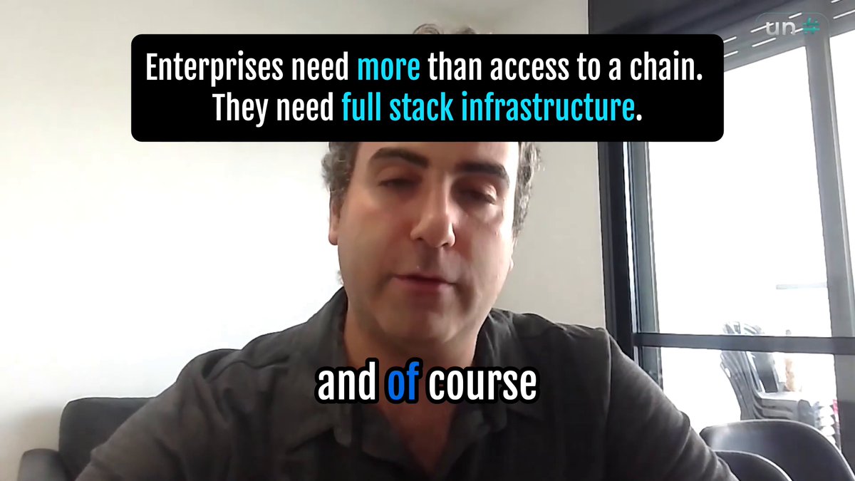 The image features a man sitting at a desk, wearing a black shirt. The background of the image shows a window with blinds, suggesting that he might be indoors or in an office setting. There are also some text elements present on the image, including the words "and of course" and " Enterprise Services". These words seem to be related to the post about full stack infrastructure for enterprises.