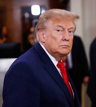 The photo shows Donald Trump in a navy blue suit with a red tie, looking over his shoulder with a serious expression, suggesting vigilance or scrutiny. The caption referencing "$214m stock trades in a month" and "GOAT" (Greatest Of All Time) implies his exceptional financial activity, with the image's intense gaze symbolizing his sharp focus on lucrative market moves.