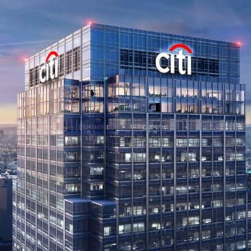 A tall glass office building displaying the "citi" logo with its iconic red arc at dusk, set against a darkening sky.