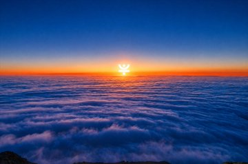 A sun rises above a vast sea of clouds, symbolizing TRON's milestone of 400 million accounts as an emerging dawn of widespread on-chain adoption. The image's lofty, expansive perspective mirrors the scale and momentum of real demand driving the network's continuous growth beyond short-term hype.