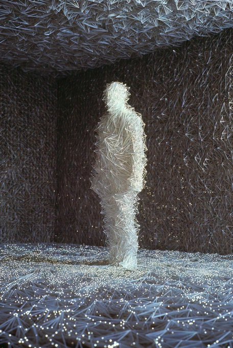 The image features a sculpture of a person made from wire, standing in front of a wall with many small lines or dots scattered across it. The sculpture appears to be floating due to its wire-like structure. The background of the image is dark, which contrasts with the white and gray elements of the sculpture. The post that accompanies this image reads: "What moves you tracking attention attracting tension". This phrase suggests that the artwork has a strong visual impact on viewers, drawing their attention and creating an atmosphere of tension or unease.
