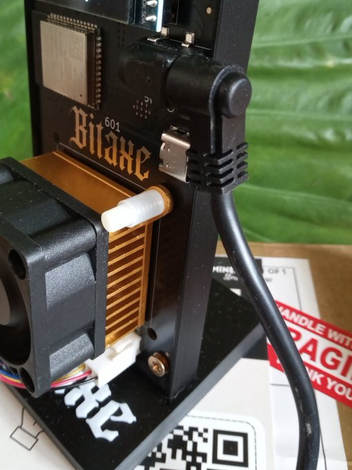 A Bitaxe 601 mining device is shown plugged into a power source, representing the "decentralized hashrate" mentioned in the post.