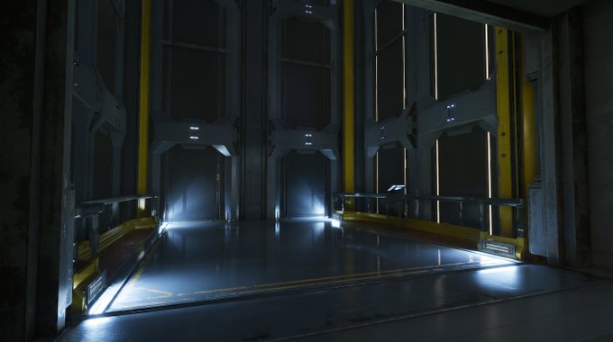 A dark, futuristic sci-fi corridor or chamber with metallic gray walls accented by yellow panels, illuminated by cool blue floor lighting and small ceiling lights.