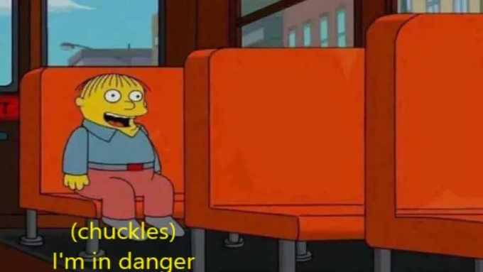 Ralph Wiggum from The Simpsons sits on a bus seat laughing, accompanied by the subtitle '(chuckles) I'm in danger'.
