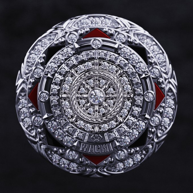 A close-up view of an ornate silver ring or emblem featuring multiple concentric circles encrusted with diamonds, accented with red triangular inlays, and engraved with the word 'VIAGRA' at the bottom.