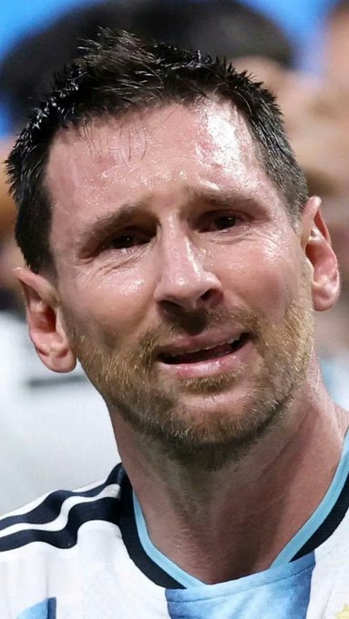 Lionel Messi, wearing Argentina's iconic light blue and white striped jersey, appears visibly emotional with tears on his face during what seems to be a World Cup match. The image connects to the post's narrative about a trader who earned $20M during the World Cup, with Messi's emotional state highlighting the high-stakes nature of the Argentina vs. England match being discussed.