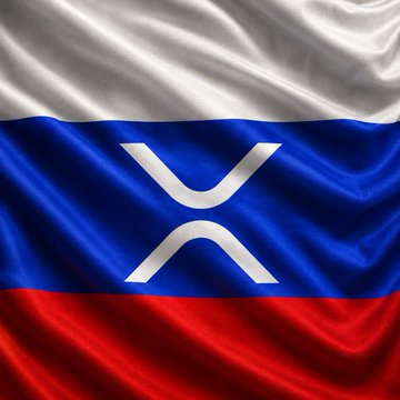 The image features a close-up view of a Russian flag with the word "XR" written across it, which stands out against the red, white, and blue colors. The flag appears to be waving or blowing in the wind, adding a sense of movement and dynamism to the scene. The background is blurred, drawing attention to the flag and its message about embracing new technologies like cryptocurrency for international trade.