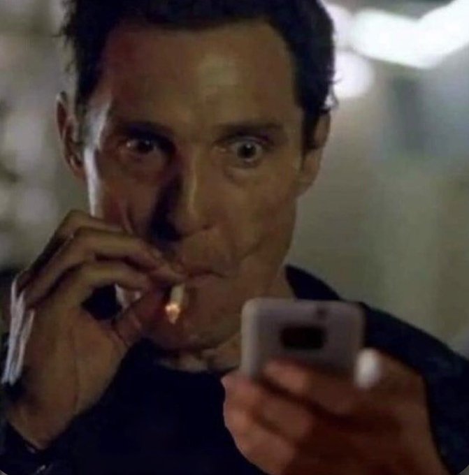 A man with wide, shocked eyes holds a cigarette in one hand and a smartphone in the other, staring intently at the screen. The image humorously captures the post's message about remaining cautious and not overreacting to temporary bullish price action, as the man's exaggerated alarm conveys the "calm down" sentiment the poster is urging toward overly enthusiastic traders.