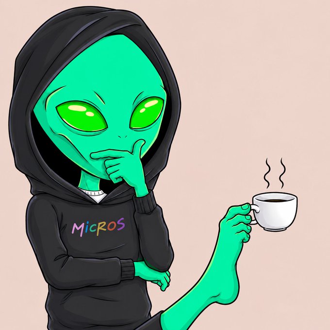 A green cartoon alien wearing a black hoodie with the text 'MicROS' in colorful letters holds a steaming white coffee cup while thoughtfully touching its chin.