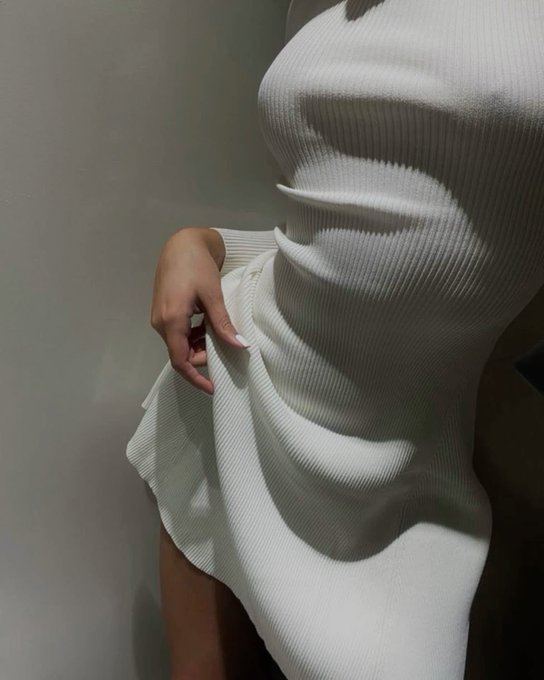 A close-up photo shows the side profile of a person wearing a fitted, ribbed white dress.
