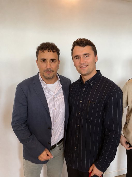 Two men pose together against a plain white wall—one in a blue blazer over a checkered shirt, the other in a navy pinstripe button-down—both smiling for the camera. The image serves as a throwback photo from Avalanche House Istanbul in 2023, with the poster having blurred his face for anonymity while sharing well-wishes for the upcoming AVAX Summit NYC.